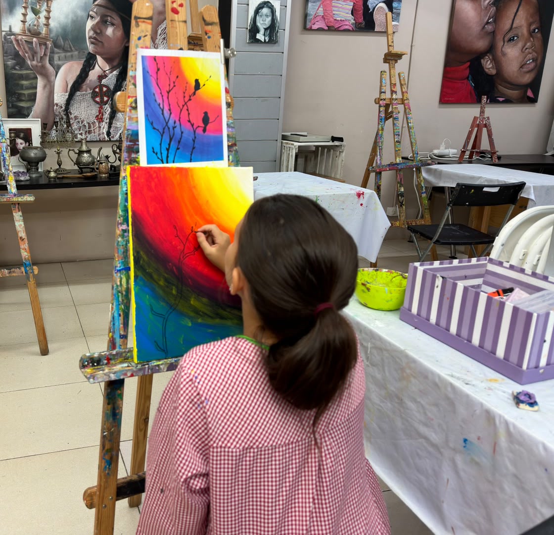 Niña pintando un degradado de colores en el taller infantil